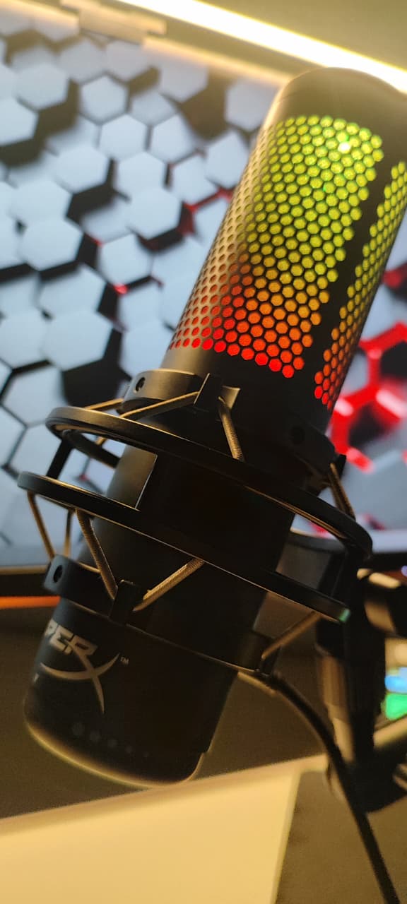 HyperX QuadCast S exibindo iluminação RGB em um setup de streaming